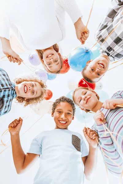Дети улыбаются и держат воздушные шары — стоковое фото