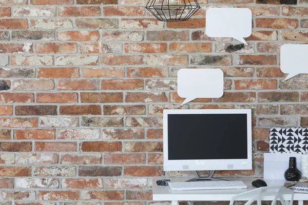 Computer op een bureau en een mockup tekstballonnen — Stockfoto