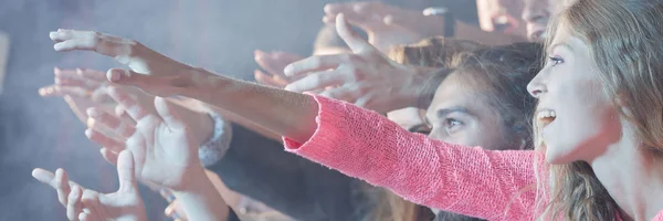 Jeunes gens souriants pendant le concert — Photo