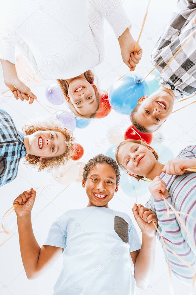 Kids smiling and holding balloons