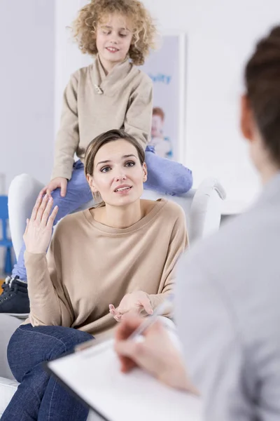 Pojken sitter bakom mor — Stockfoto