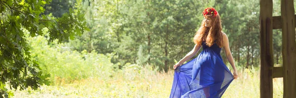 Vrouw in blauwe jurk in het bos — Stockfoto