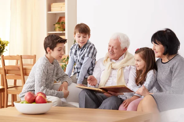 Grandparents and grandchildren with family album — Stock Photo, Image