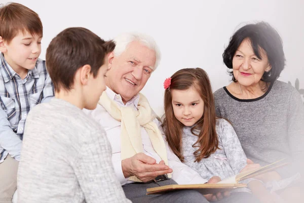 Familia viendo álbum de fotos — Foto de Stock