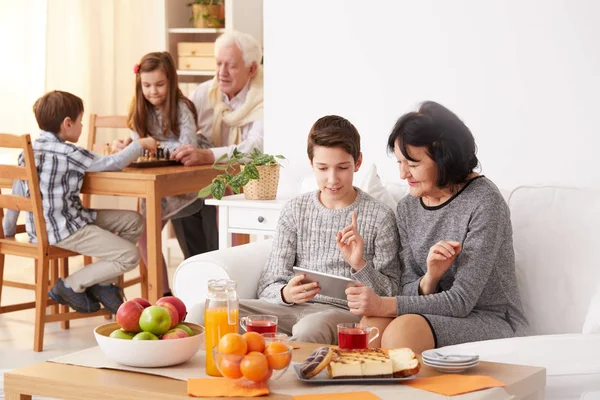 Chico enseñando a la abuela a usar una tableta —  Fotos de Stock