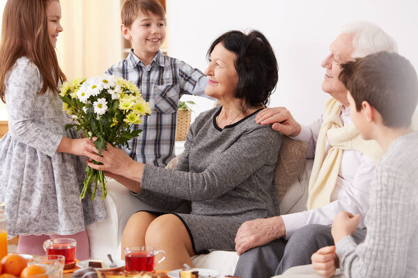 Девушка дарит цветы своей бабушке
