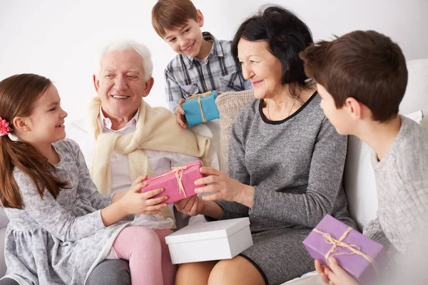 Grandparents and grandchildren exchanging gifts — Stock Photo, Image