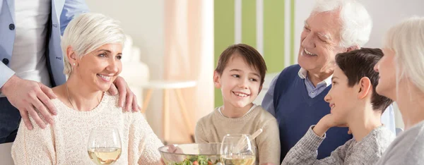 Mãe sorridente com filhos durante o jantar — Fotografia de Stock