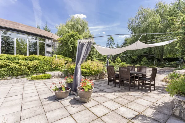 Giardino con terrazza pavimentata con tavolo — Foto Stock