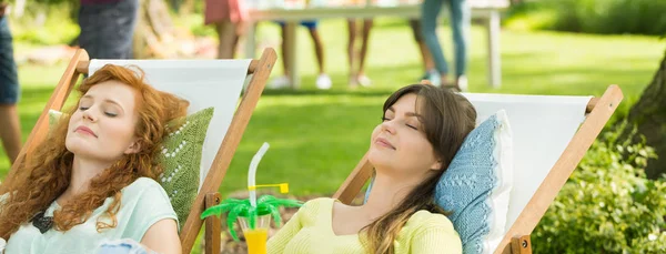 Chicas tomando el sol en las tumbonas — Foto de Stock