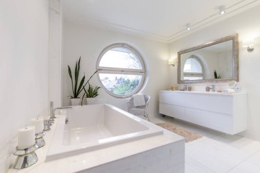 Bir circulal pencere ile minimalist beyaz banyo
