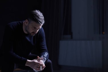 Oturma ve bir şişe tutan adam