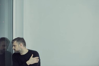 bir duvara oturan adam