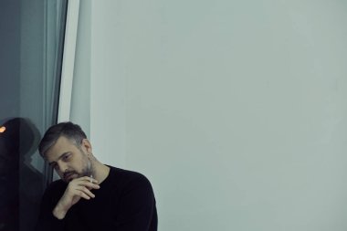 Adam pencere yanında sigara