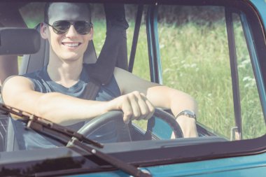 Genç adam araba kullanıyor.