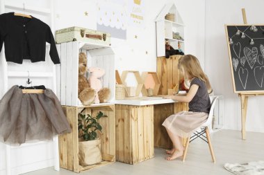 Rahat oda içinde bir masada oturan kız