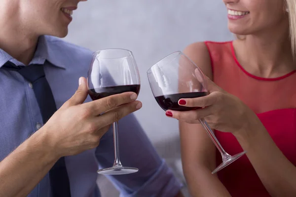 Casal jovem comemorando com vinho tinto — Fotografia de Stock