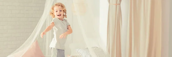 Gelukkig kind spelen in het bed — Stockfoto