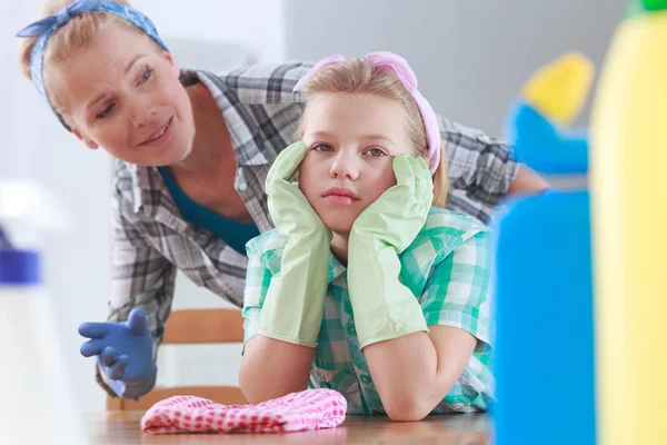 Mädchen mit Gummihandschuhen sitzt an einem Tisch — Stockfoto