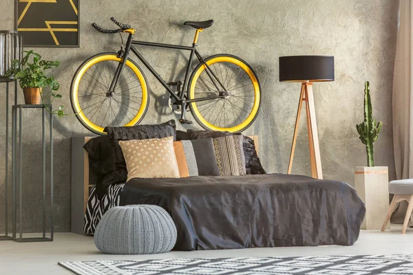 在床的上方挂着的自行车 — 图库照片