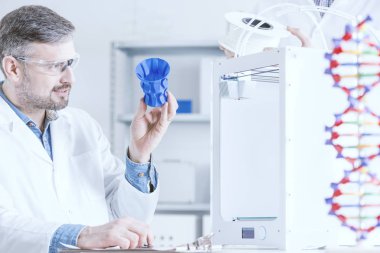Man examinig the 3D printout clipart