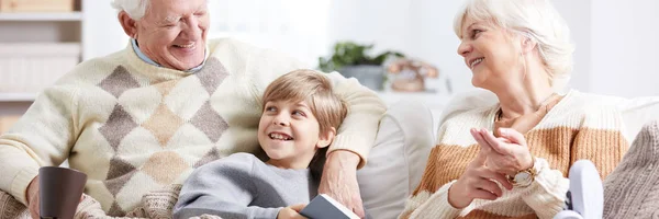 Junge liest mit Großeltern ein Buch — Stockfoto