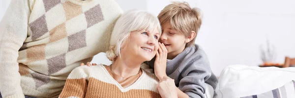 Garçon chuchotant à l'oreille de grand-mère — Photo