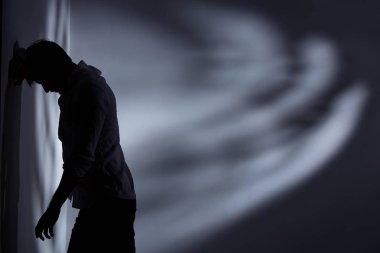 Adam ayakta duvara yakın