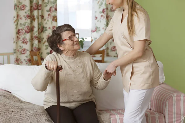 Caregiver helping senior woman — Stock Photo, Image