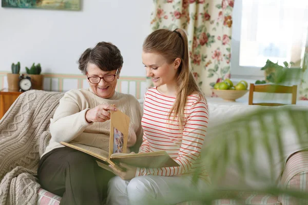 Oma und Enkelin schauen sich Fotoalbum an — Stockfoto