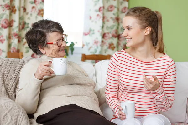 Старшая женщина и внучка пьют чай — стоковое фото