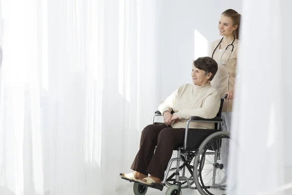 Senior woman on wheelchair and caregiver — Stock Photo, Image