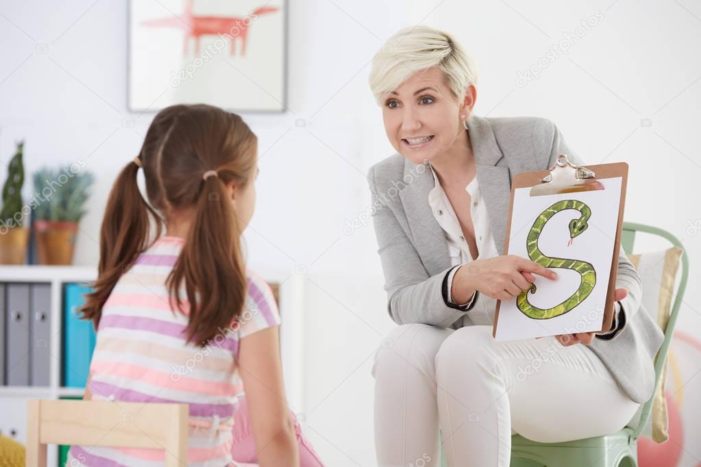 Speech pathologist with young girl