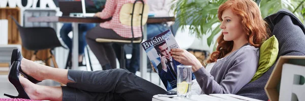 Businesswoman reading business magazine