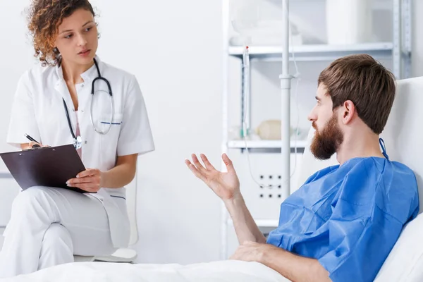 Paciente traumatizado conversando com enfermeiro — Fotografia de Stock