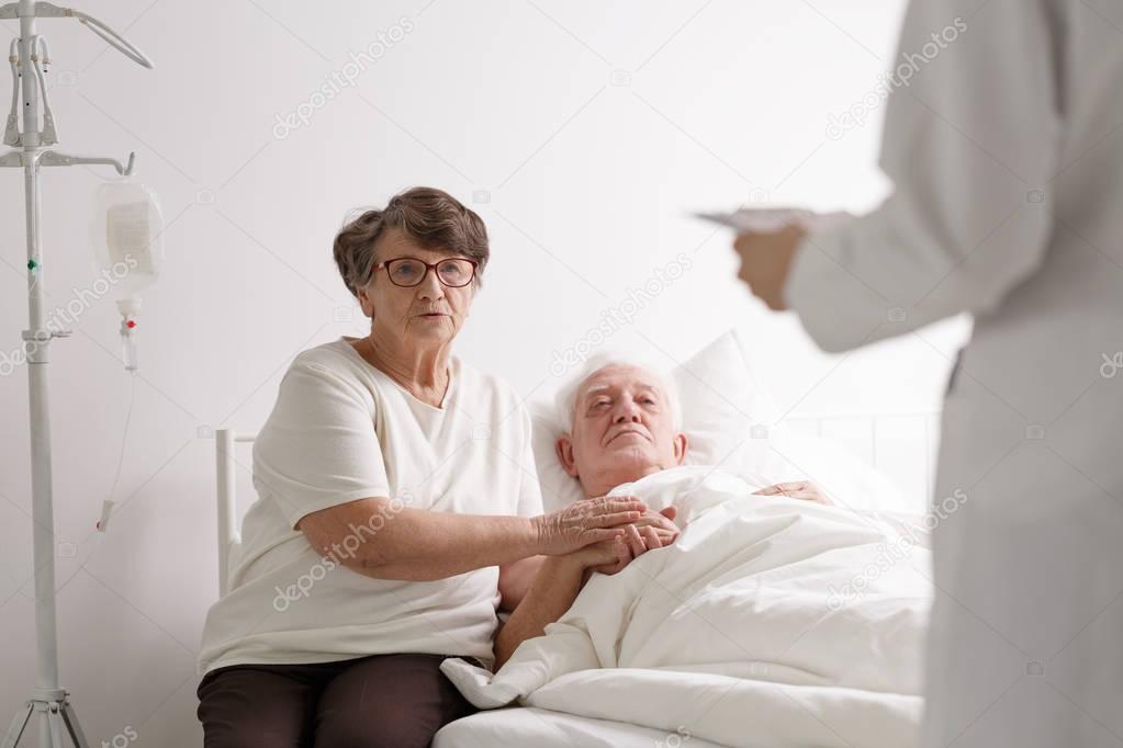 Man with wife listening diagnosis