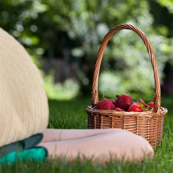 Person som vilar med korg med jordgubbar — Stockfoto