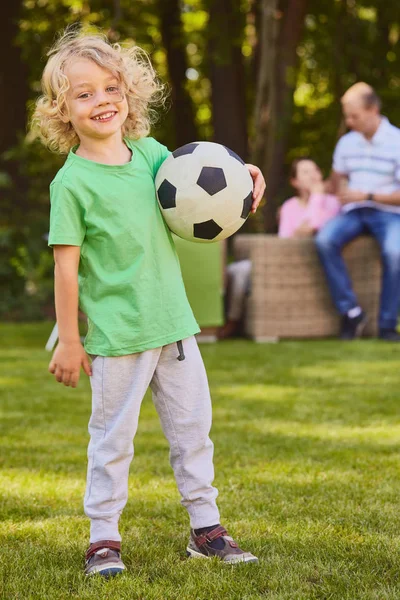 Hijo sosteniendo pelota de fútbol —  Fotos de Stock