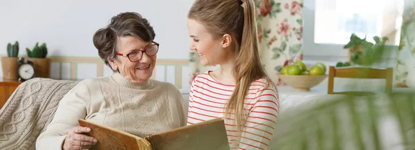 Oma und Enkelin schauen sich Fotoalbum an — Stockfoto