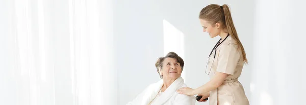 Woman on wheelchair and caregiver — Stock Photo, Image