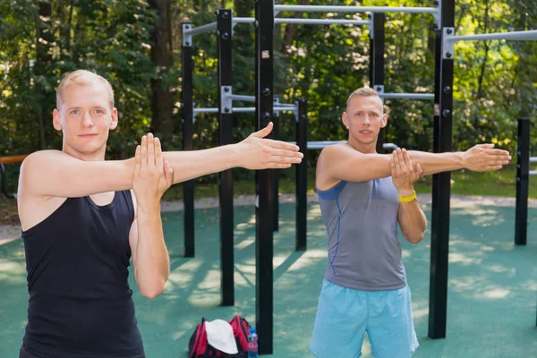 Männer dehnen sich im Outdoor-Fitnessstudio — Stockfoto