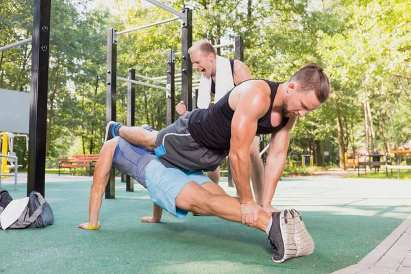 Mannen doen push-ups in een park — Stockfoto