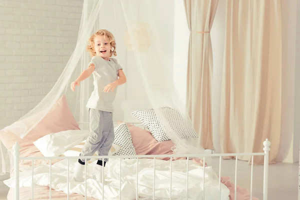 Jongen springen op het bed — Stockfoto