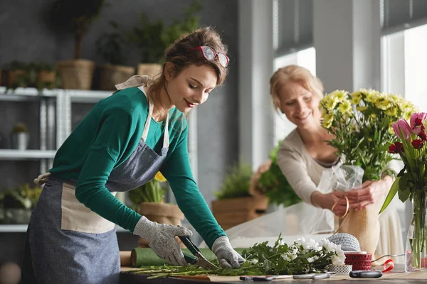 Mujer joven en floristería —  Fotos de Stock