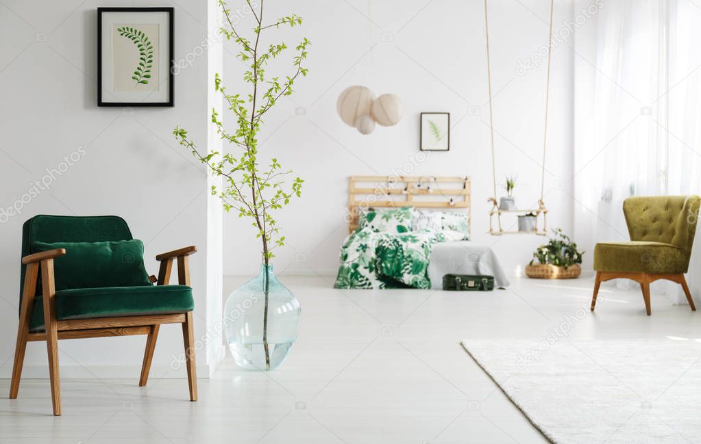 Open bedroom with green armchair