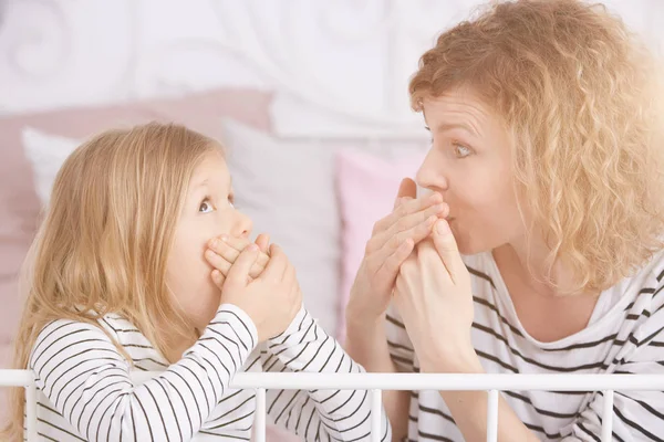 Daughter and mom covering mouths — Stock Photo, Image