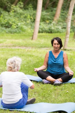 Yoga eğitmeni ve yaşlı bir kadın