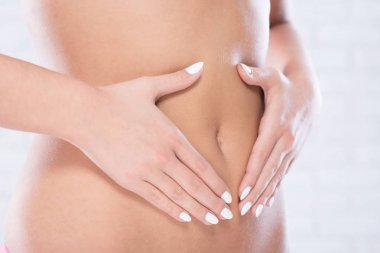 Kadın karnına dokunuyor.