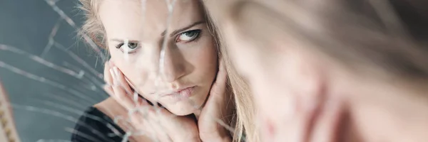 Junge Frau im zerbrochenen Spiegel — Stockfoto