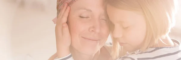 Mädchen umarmt das Gesicht der Mutter — Stockfoto